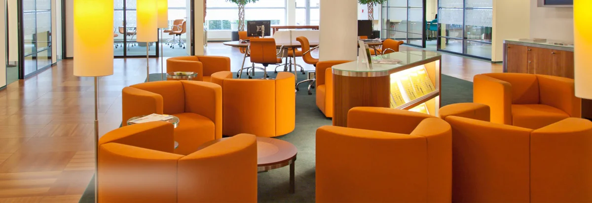 A bright commercial common area with seating, glass and hard flooring, 